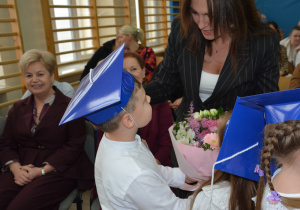 Chłopiec wręcza kwiaty