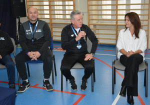 dwóch mężczyzn w sportowych strojach, kobieta po prawej stronie