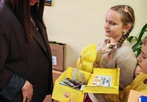 Uczniowie rozdają karteczki z miłymi słowami