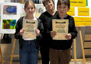 Ola i Antoś prezentują swoje dyplomy