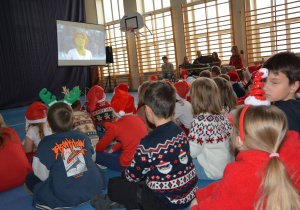 Dzieci w mikołajowych czapkach, odwrócone w stronę okranu