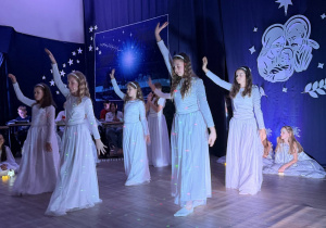 Dziewczynki w białych sukniach tańczą