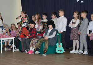 Dzieci przebrane za seniorów siedfzą na kanapie