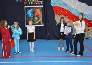 Dzieci w kolorowych przebraniach na tle dekoracji i żywiołach