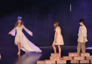 Dziewczynka i chłopiec, obok dziewczyna w białej sukni