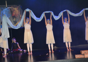 Dziewczynki w białych sukienkach z szarfą w głoniach