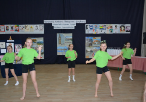 dziewczynki w jaskrawych strojach, na tle dekoracji konkursowej