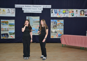 Dziewczynki z mikrofonami i na tle dekoracji konkursowej