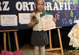 Hania z klasy 3b prezentuje otrzymaną statuetkę i dyplom