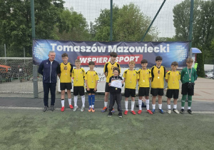 Chłopcy wraz ze swoim trenerem odbierają dyplomy i medale