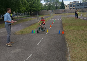Chłopiec pokonuje slalom na rowerze